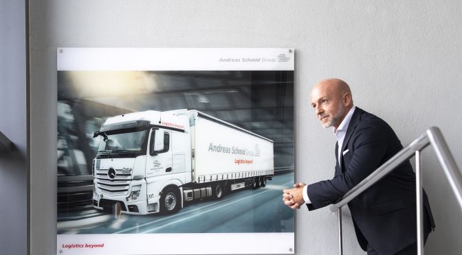 CEO in front of a picture of an Andreas Schmid Group truck