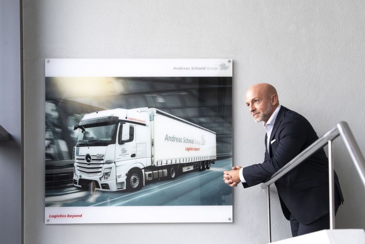 CEO in front of a picture of an Andreas Schmid Group truck